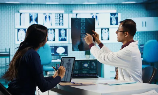 Profesionales de la salud analizando imágenes radiográficas en un entorno clínico especializado