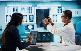 Profesionales de la salud analizando imágenes radiográficas en un entorno clínico especializado