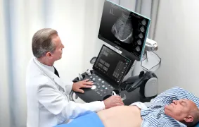 Médico realizando un estudio de ultrasonido a un paciente en camilla con el equipo Consona N8