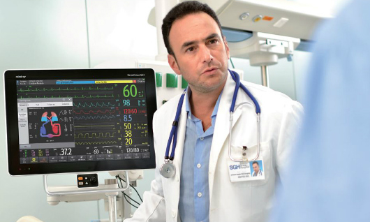 Médico monitoreando paciente en UCI.